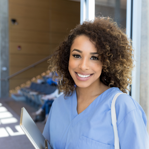 Smiling nursing student in scrubs leaves lecture hall