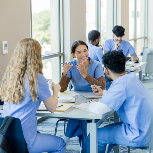 Nursing students in scrubs enjoy studying together